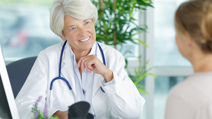 Male doctor sitting with patient