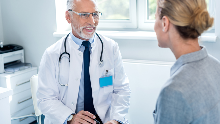 Male doctor sitting with patient